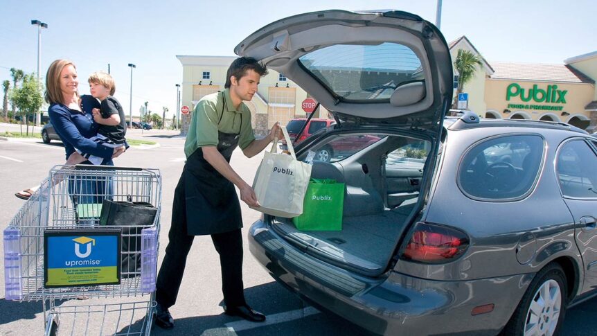 A bagger at Publix helping a mom load up her groceries in the parking lot.